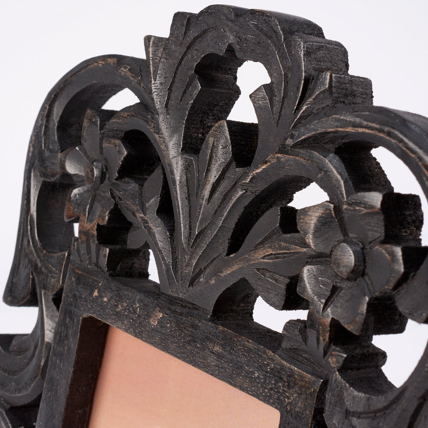 close-up of black filigree frame showing carved wood details