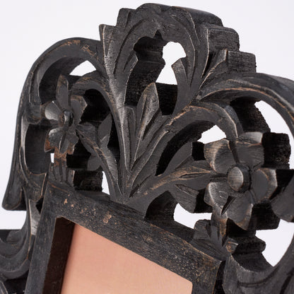 close-up of black filigree frame showing carved wood details