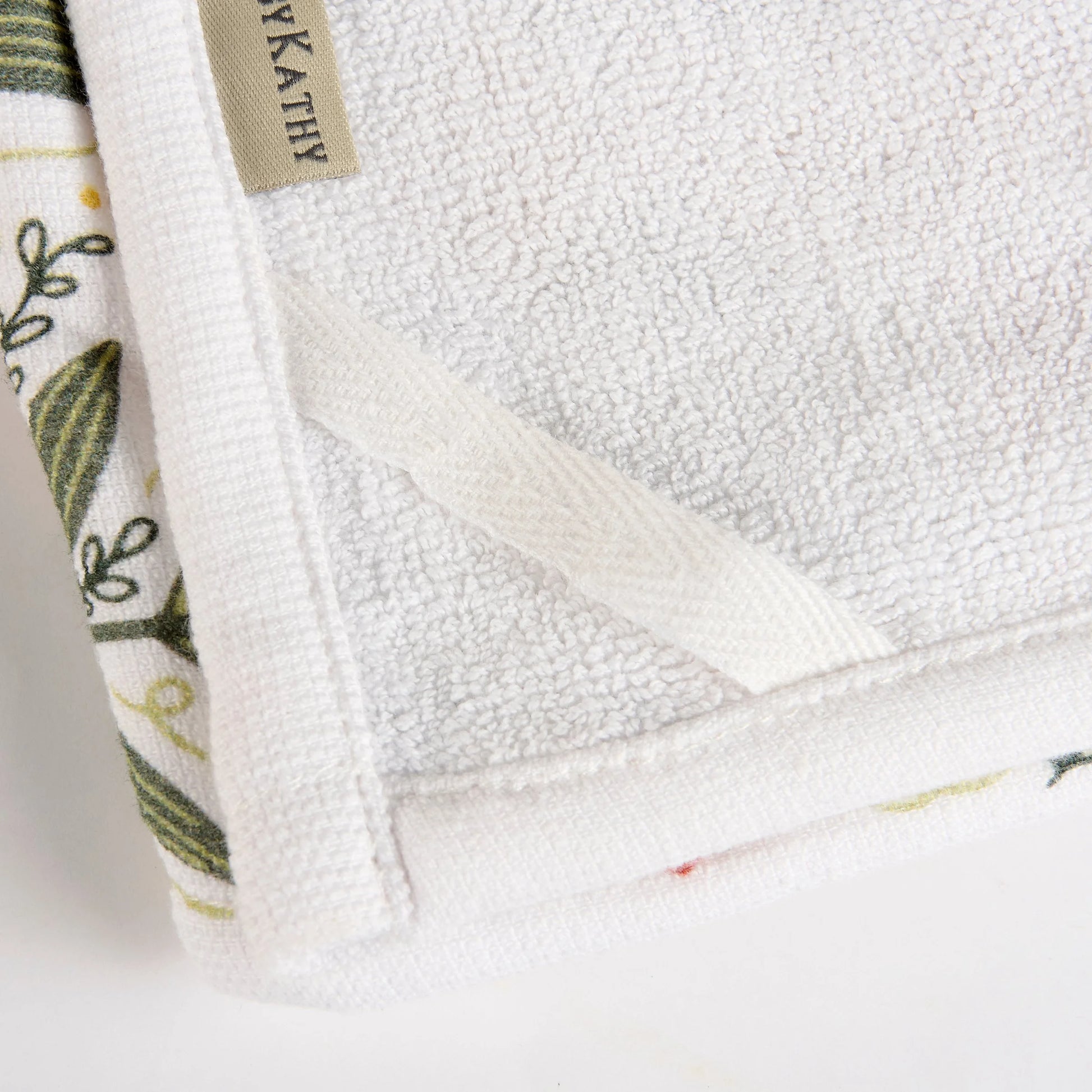Close-up of a white towel showing terrycloth backing and hanging loop