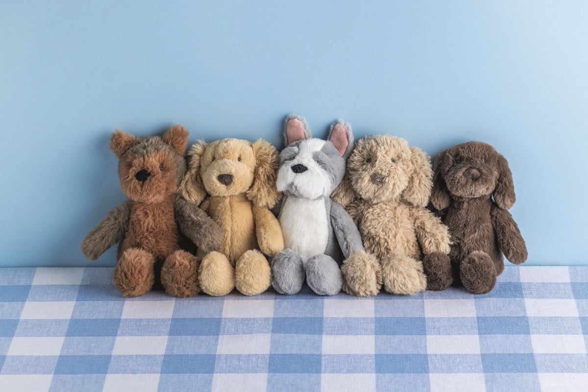 5 plush dog toys sitting on a table top