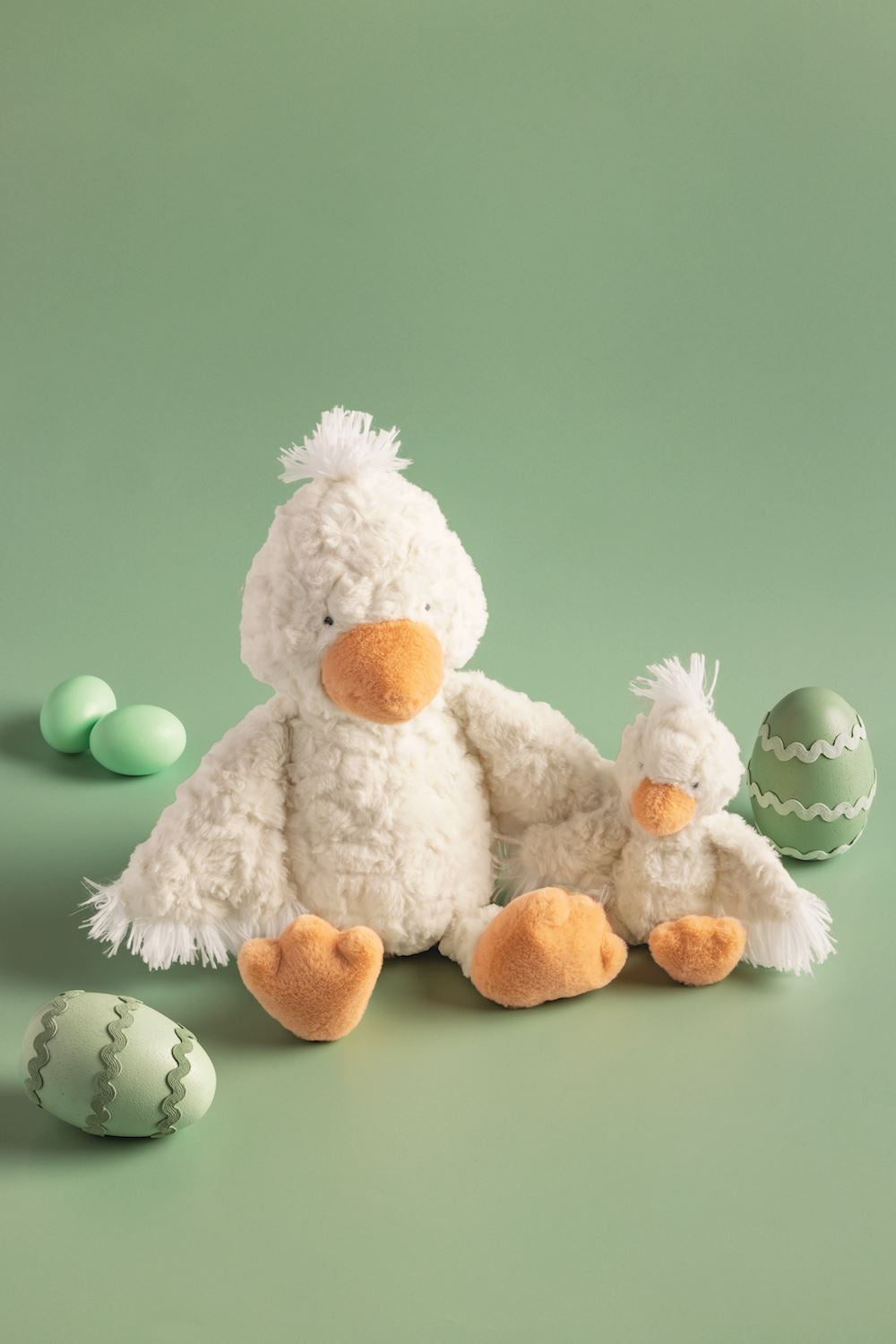 Two plush ducks and green eggs on a green background