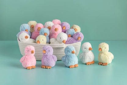Pastel-colored plush chicks in a basket on a light blue background