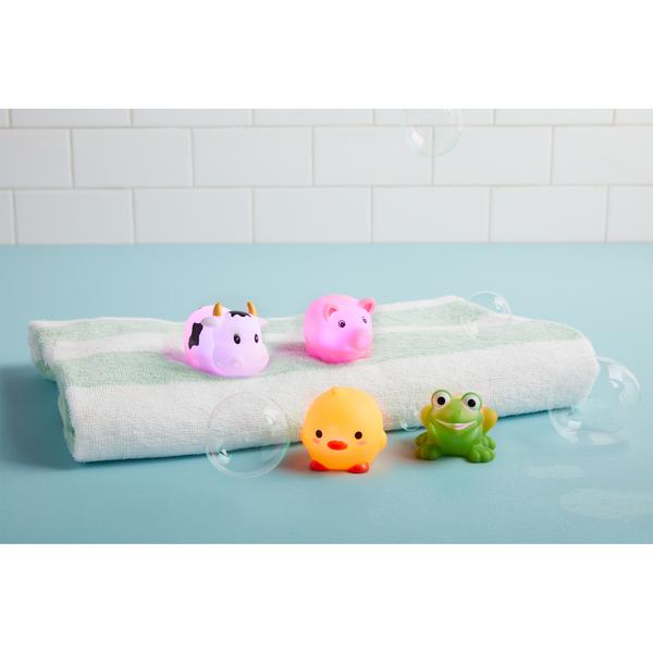 cow, pig, chick, and frog Light-Up Farm Animal Bath Toy Set arranged with a towel and bubbles on a blue surface