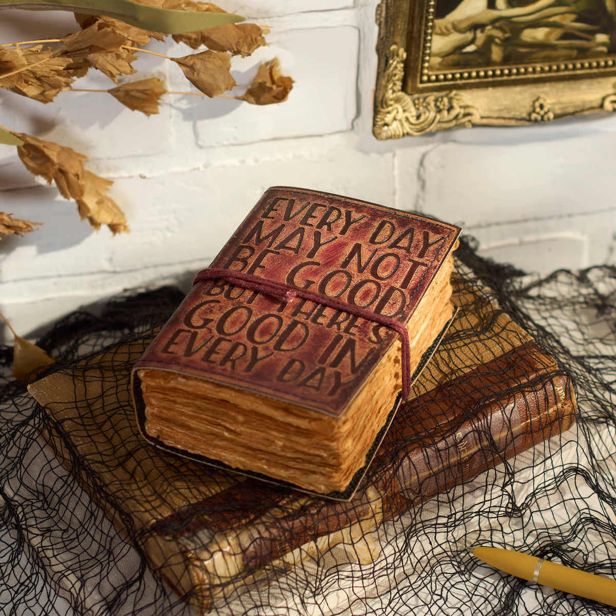 Good In Every Day Journal laying on another book on a table