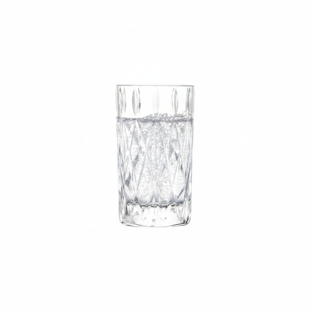 drinking glass with cut diamond design filled with a clear, sparkling beverage