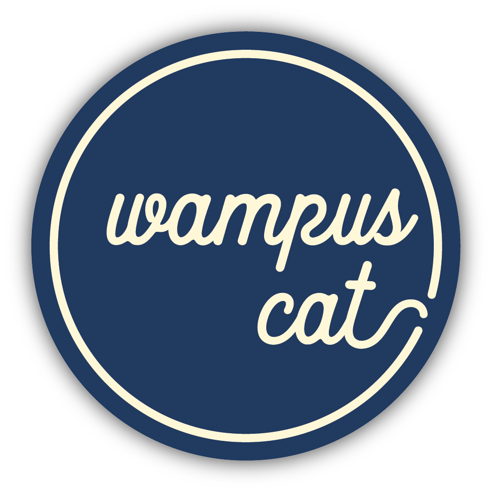 circle blue sticker with creamy white text "wampus cat"