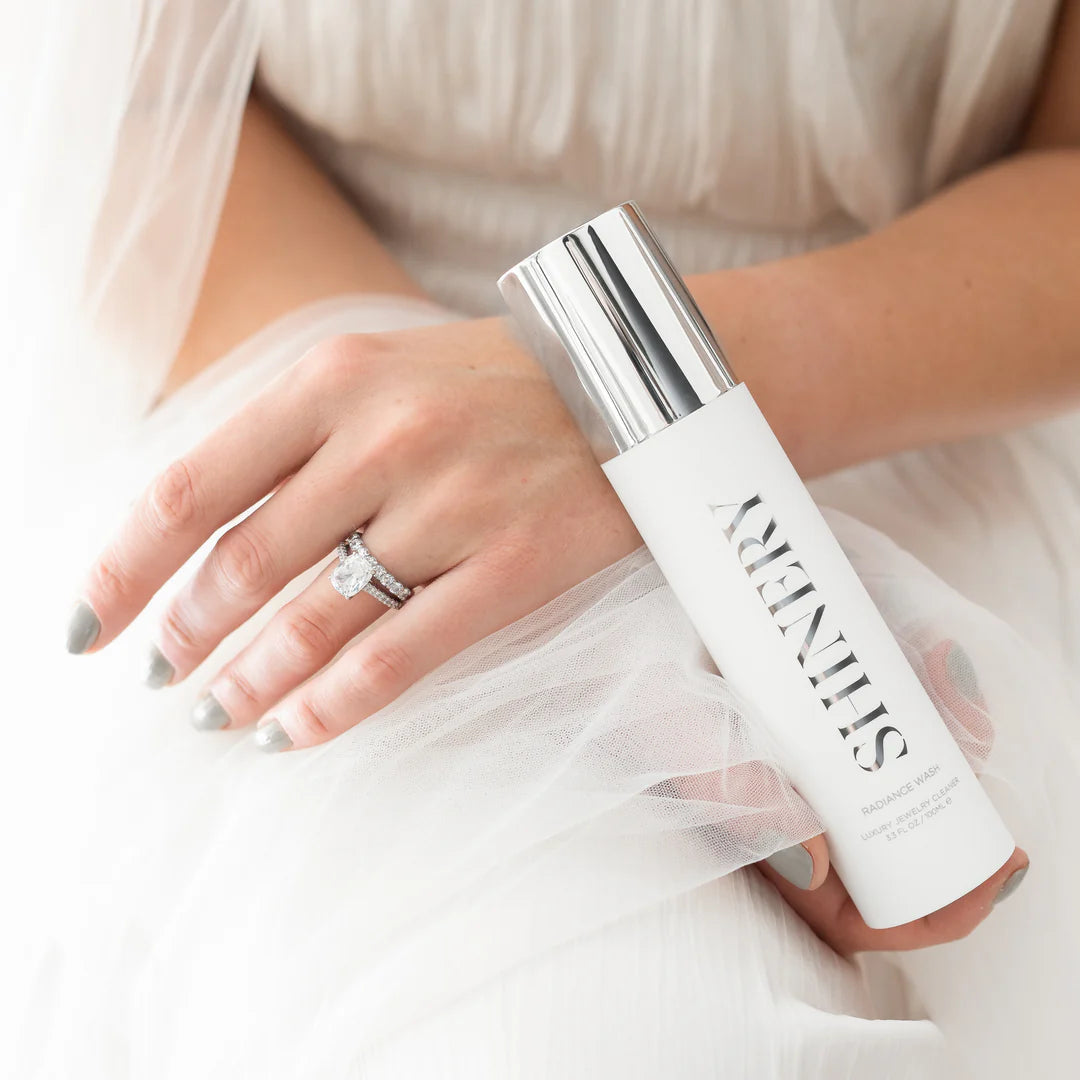 Person wearing what appears to be a bridal gown and veil holding a bottle of shinery jewelry wash