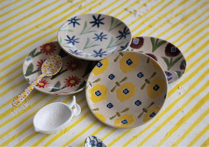 colorful ceramic plates with floral patterns arranged on a yellow striped background