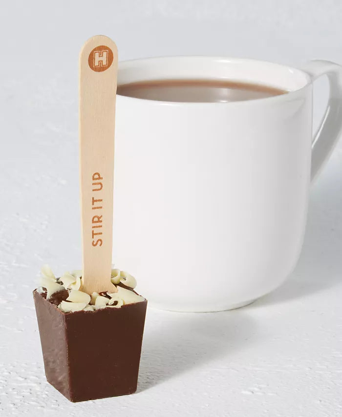 mug of cocoa and dunking spoon arranged on a white table.
