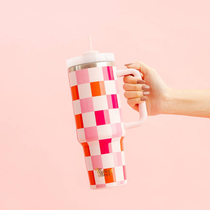 hand holding sweetheart check tumbler on a pink background.
