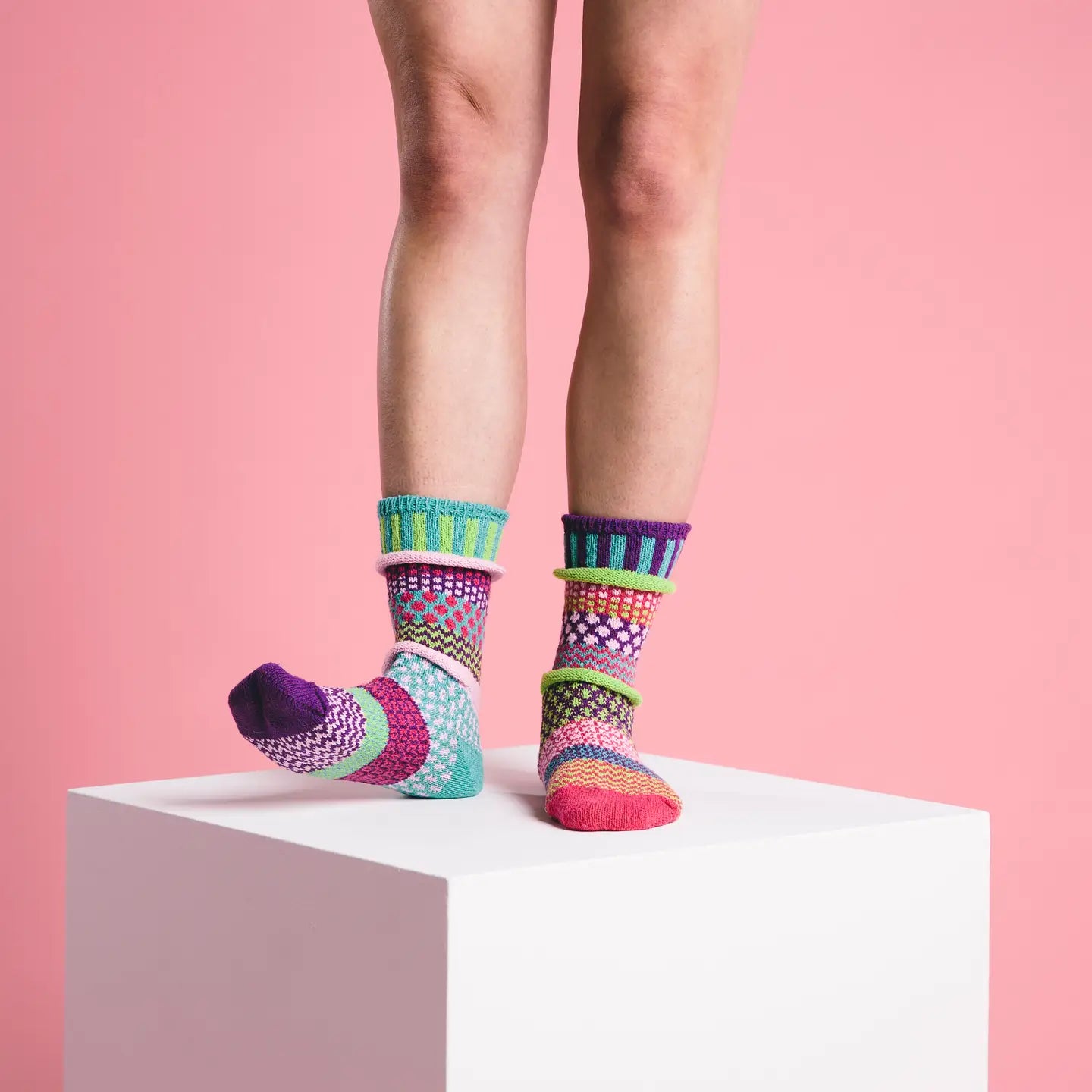 person wearing Dahlia Crew Socks standing on a white box in front of a pink background