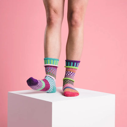person wearing Dahlia Crew Socks standing on a white box in front of a pink background