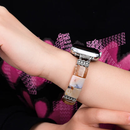 Person wearing a decorative watch strap on a wrist with a blurred background