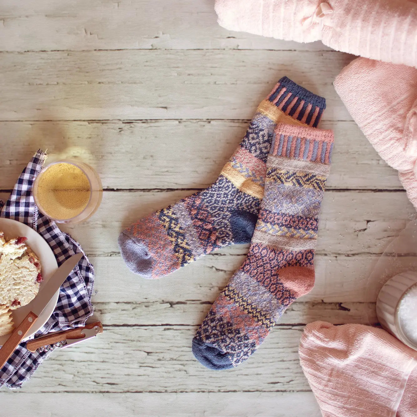 pair of Mirage Crew Socks laying on a white wooden floor with a bowl of ice cream near by