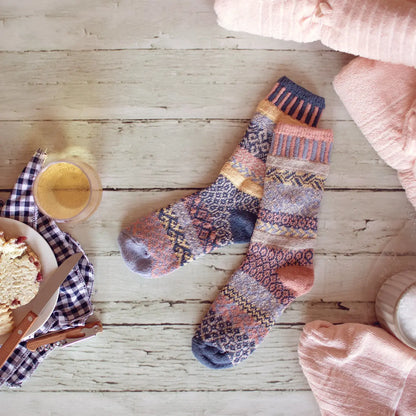 pair of Mirage Crew Socks laying on a white wooden floor with a bowl of ice cream near by