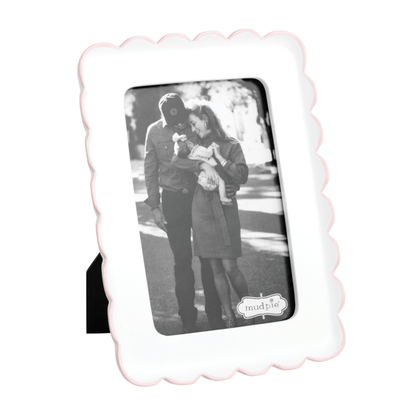 Scalloped photo frame with a thin pink trim and a black and white photo of a couple 