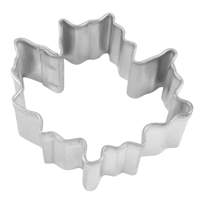 Metallic cookie cutter with maple leaf shape on a white background