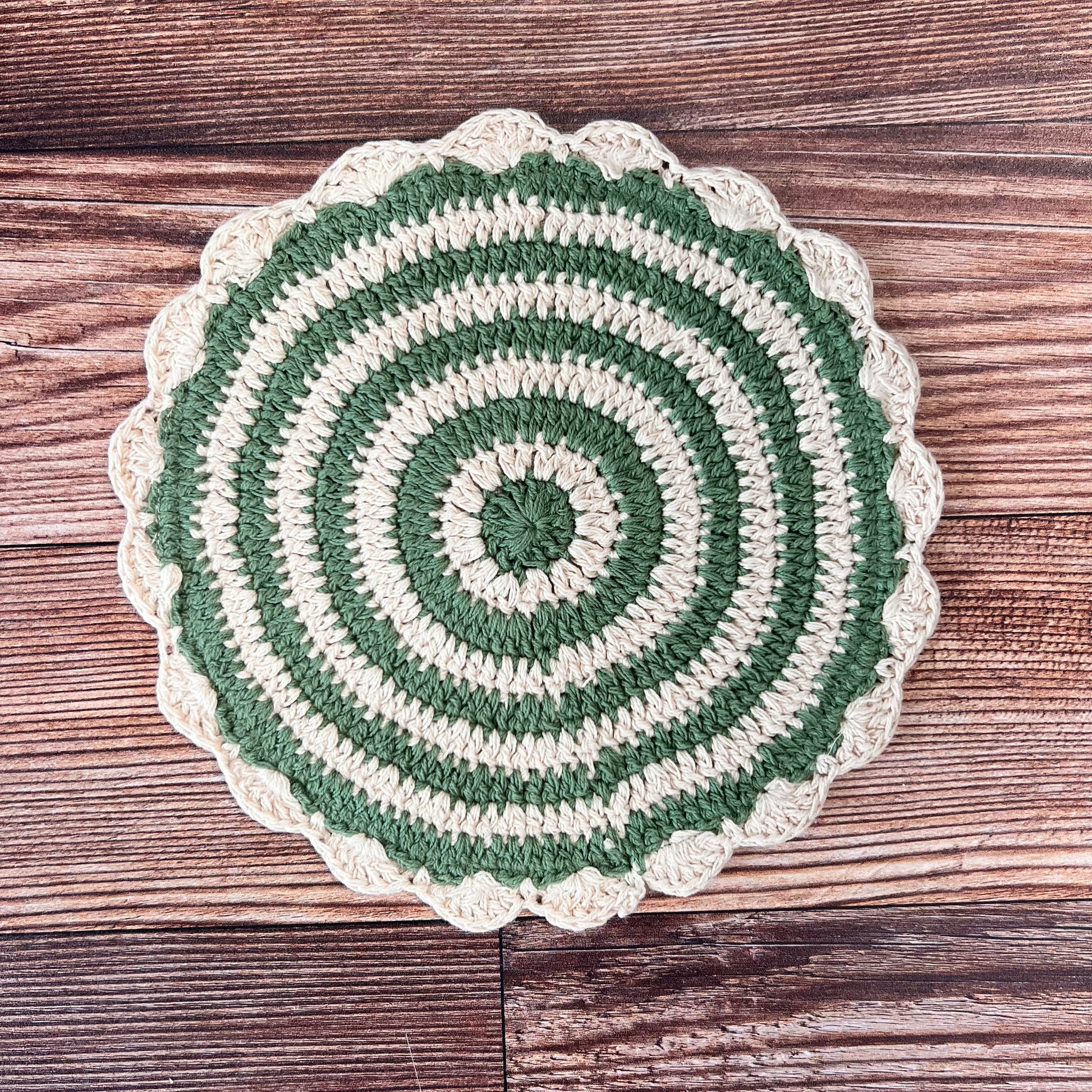 green and off-white crocheted pot holder.