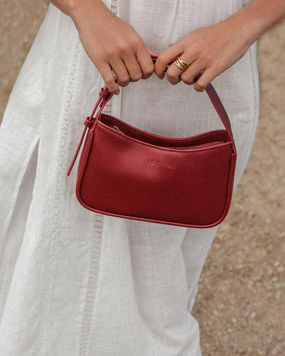 view of woman holding cherry ivy shoulder bag