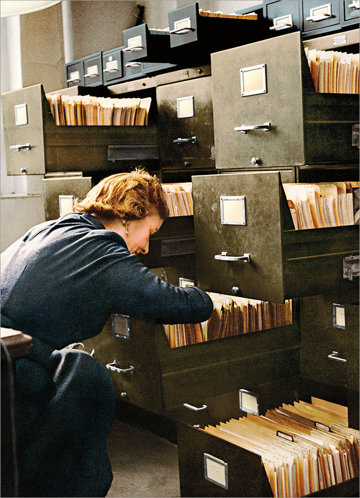 front of card is a woman digging through a file cabinet in an office