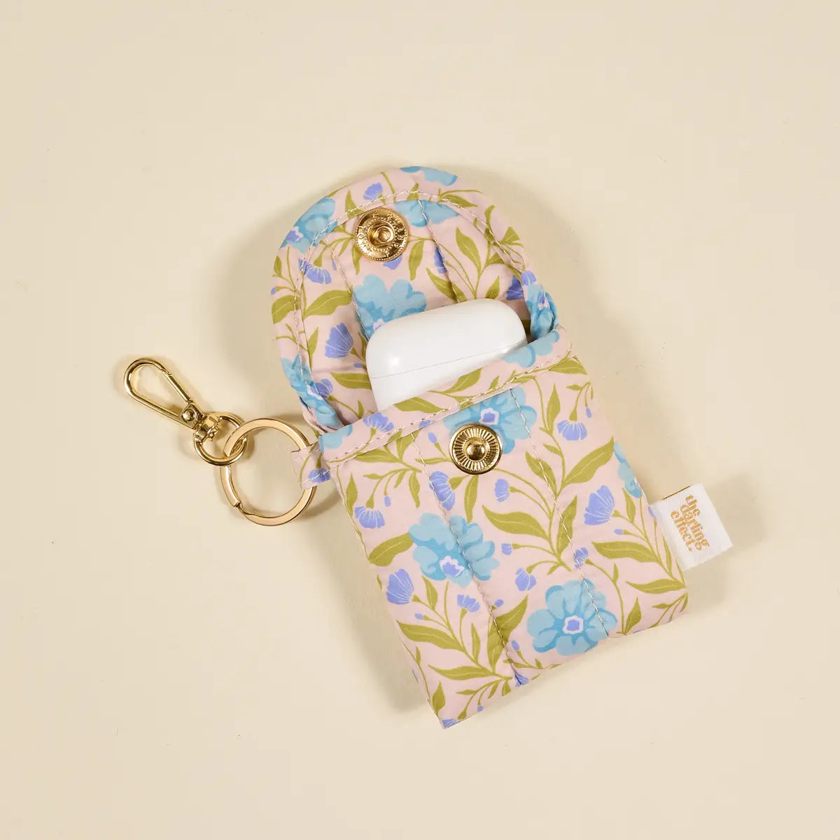 Floral patterned case with keychain on a beige background