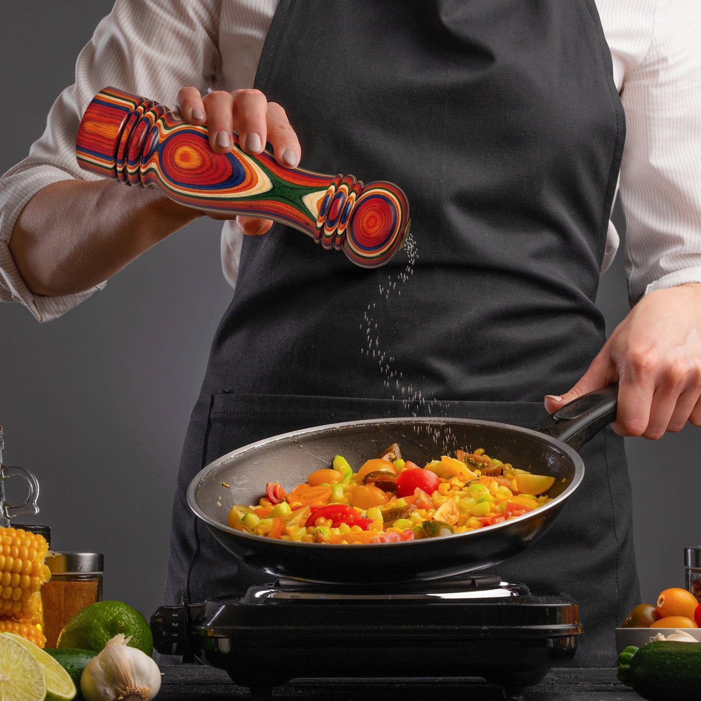 person using Marrakesh salt shaker while cooking.