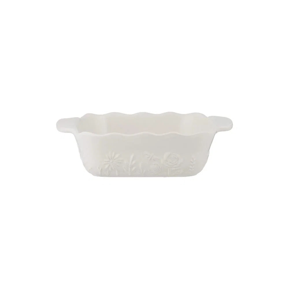 White ceramic square dish with scalloped edge on a white background