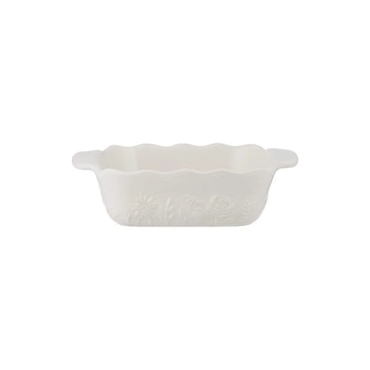 White ceramic square dish with scalloped edge on a white background