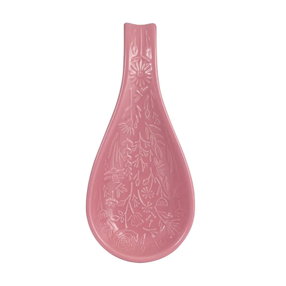 Pink ceramic spoon rest with floral patterns on a white background