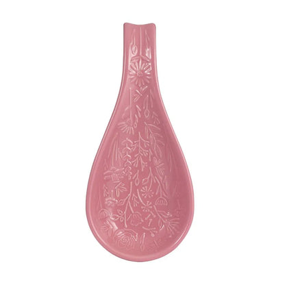Pink ceramic spoon rest with floral patterns on a white background