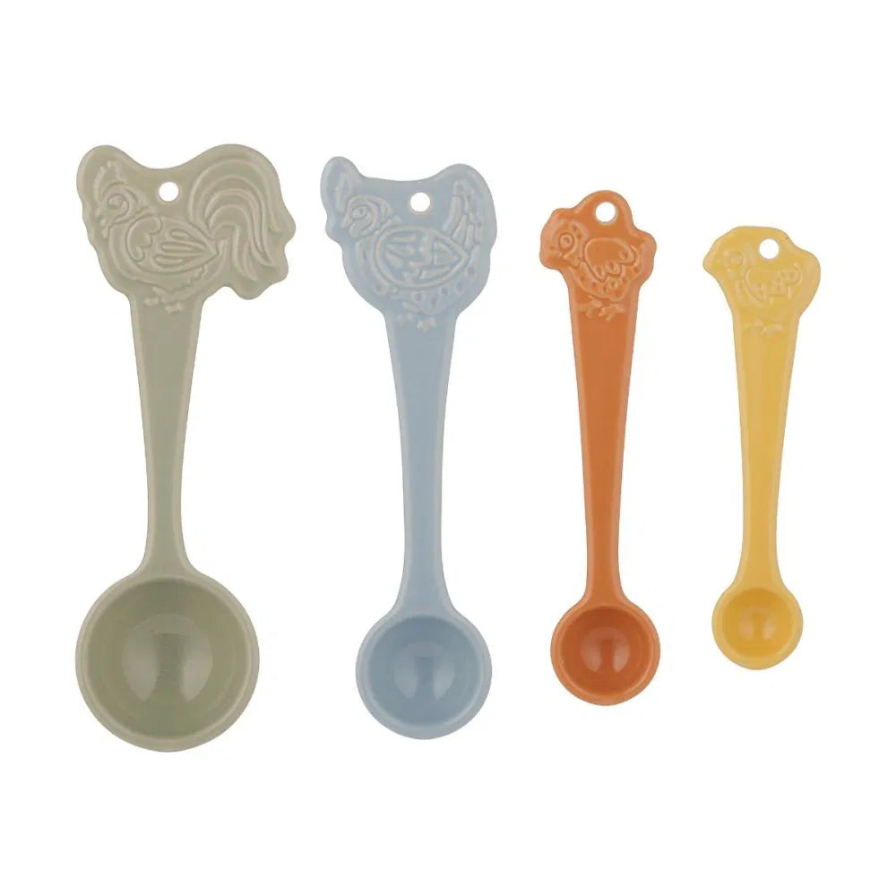 Set of four decorative measuring spoons in different colors with chicken design on the handles on a white background