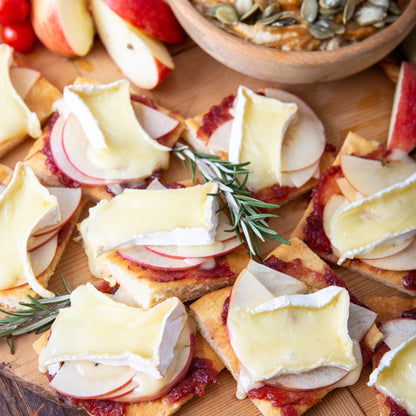 tray arranged with sliced bread topped with Cranberry Relish with Grand Marnier, brie, and sprigs of rosemary.