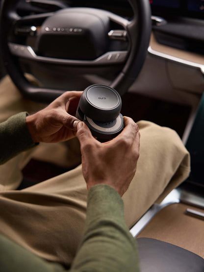 a person holding the pura car pro in their car