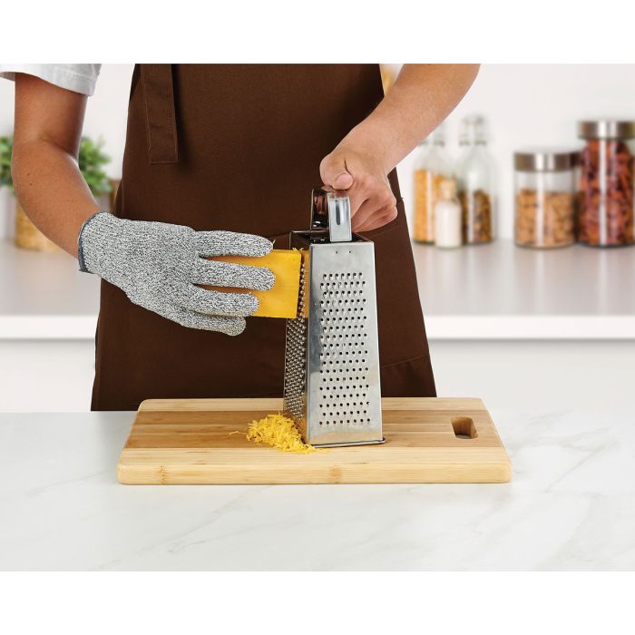 Person using a box grater on a wooden cutting board wearing a Mesh Cutting Gloves with a kitchen background