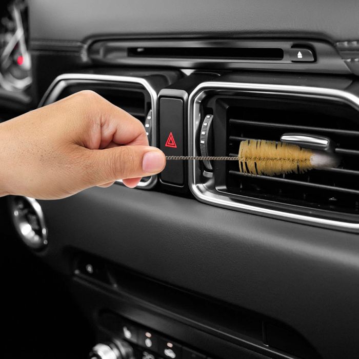 Person cleaning a car's air vent with a Soft Tip Brush 