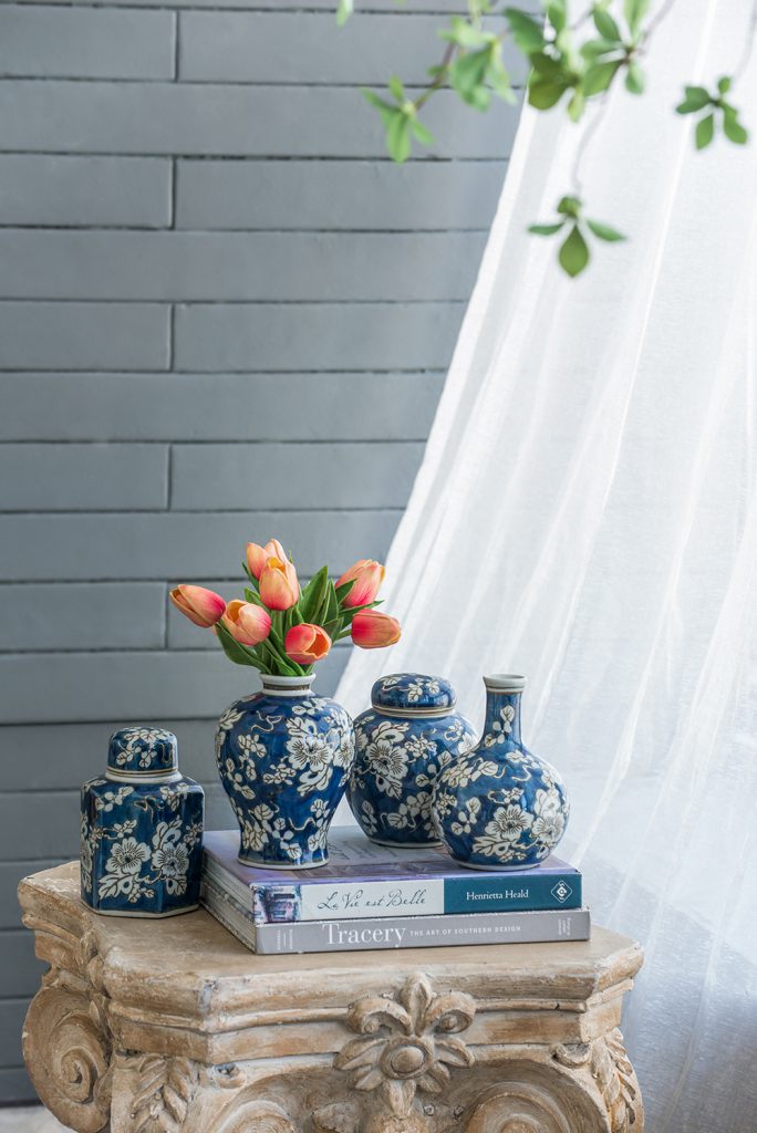 4 blue and white vases in a row on a decorated surface