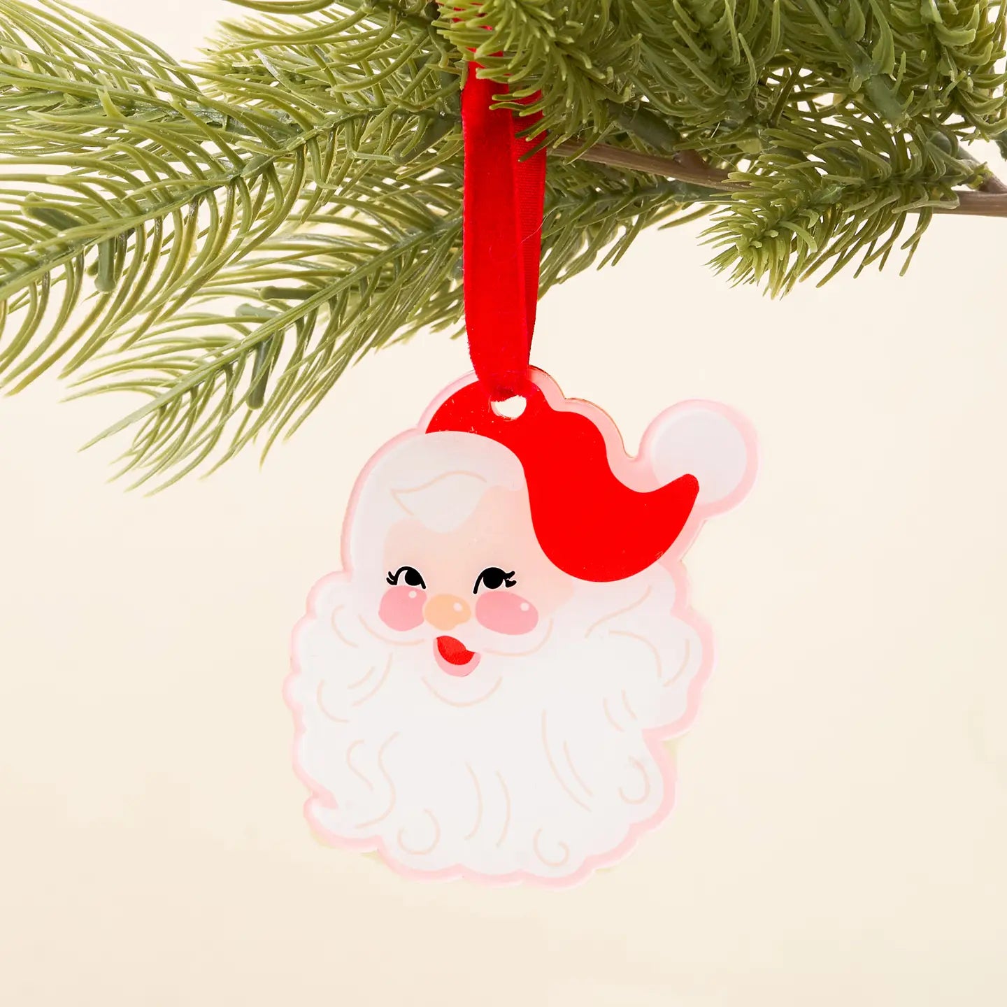 Santa Claus ornament hanging on a Christmas tree branch
