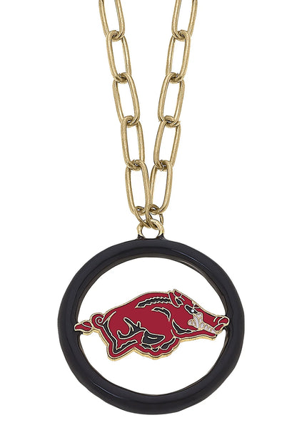 close-up of gold chain necklace with round black pendant with an arkansas razorback logo in it.