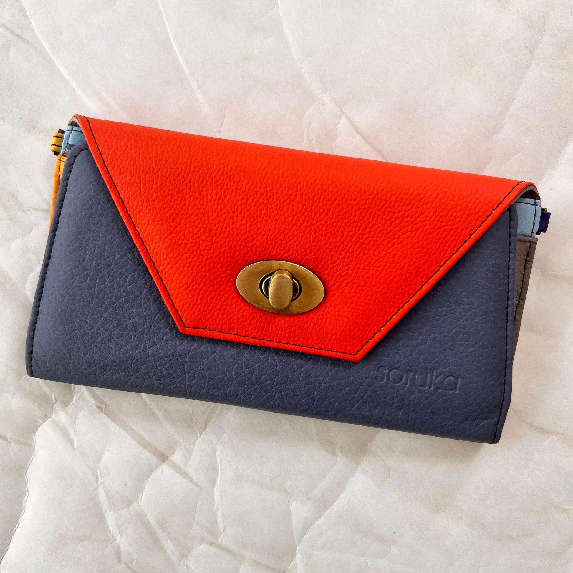 blue secret clutch wallet with orange flap.