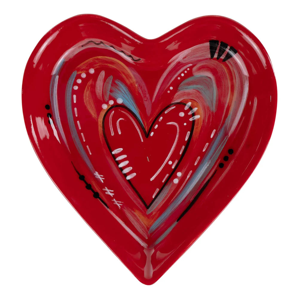 Heart-shaped red ceramic plate with artistic design on a white background
