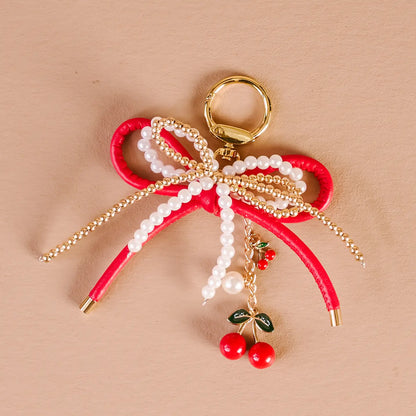cherry bliss Layered Bows Bag Charm on a beige background