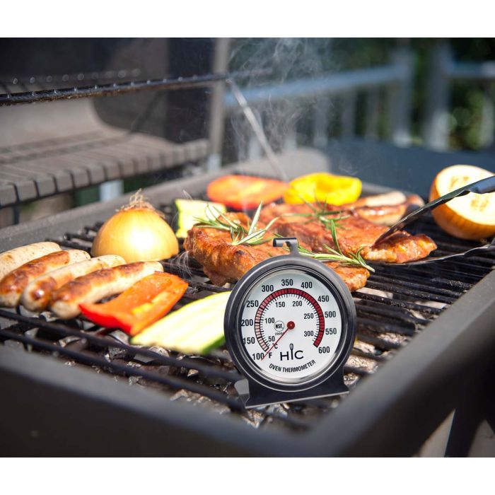 Large Face Oven Thermometer set on a grill with meats and veggies
