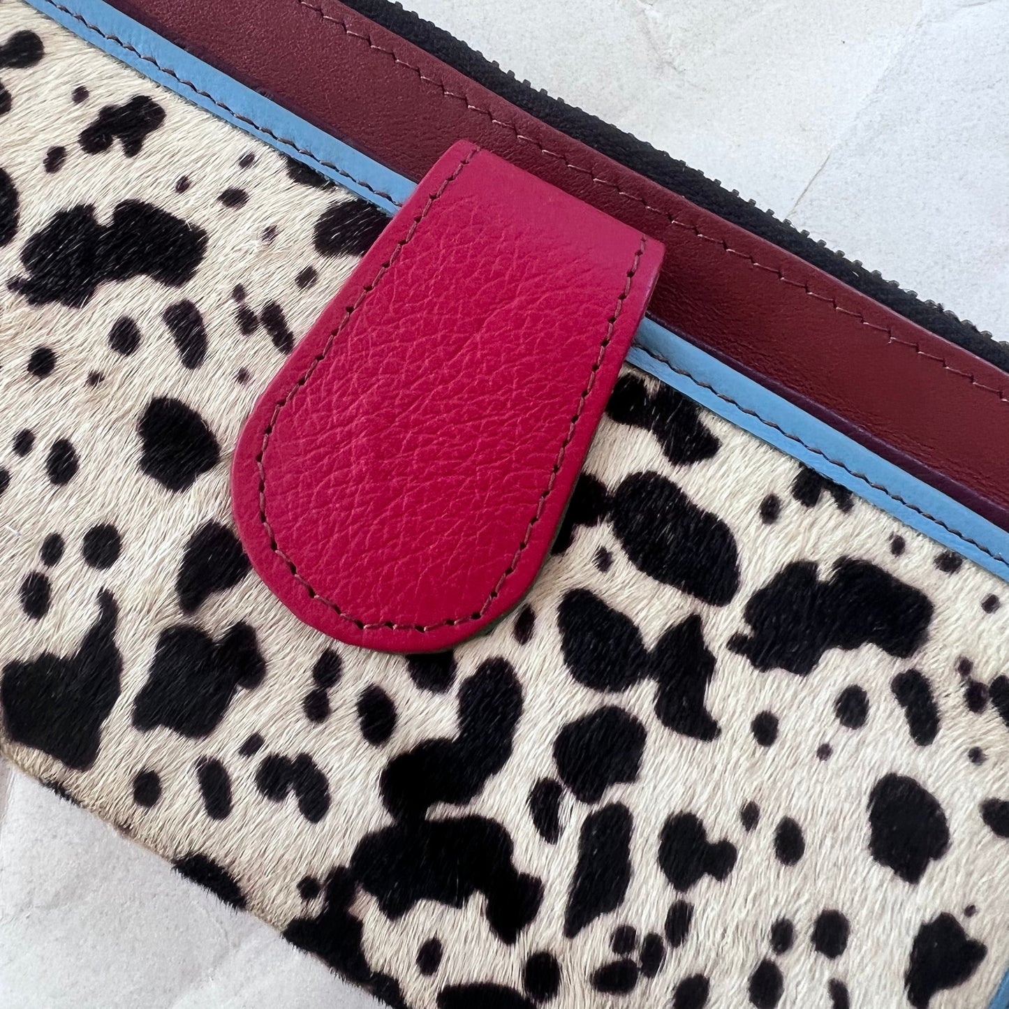 close-up of red tab on black and white spotted animal print pocket.