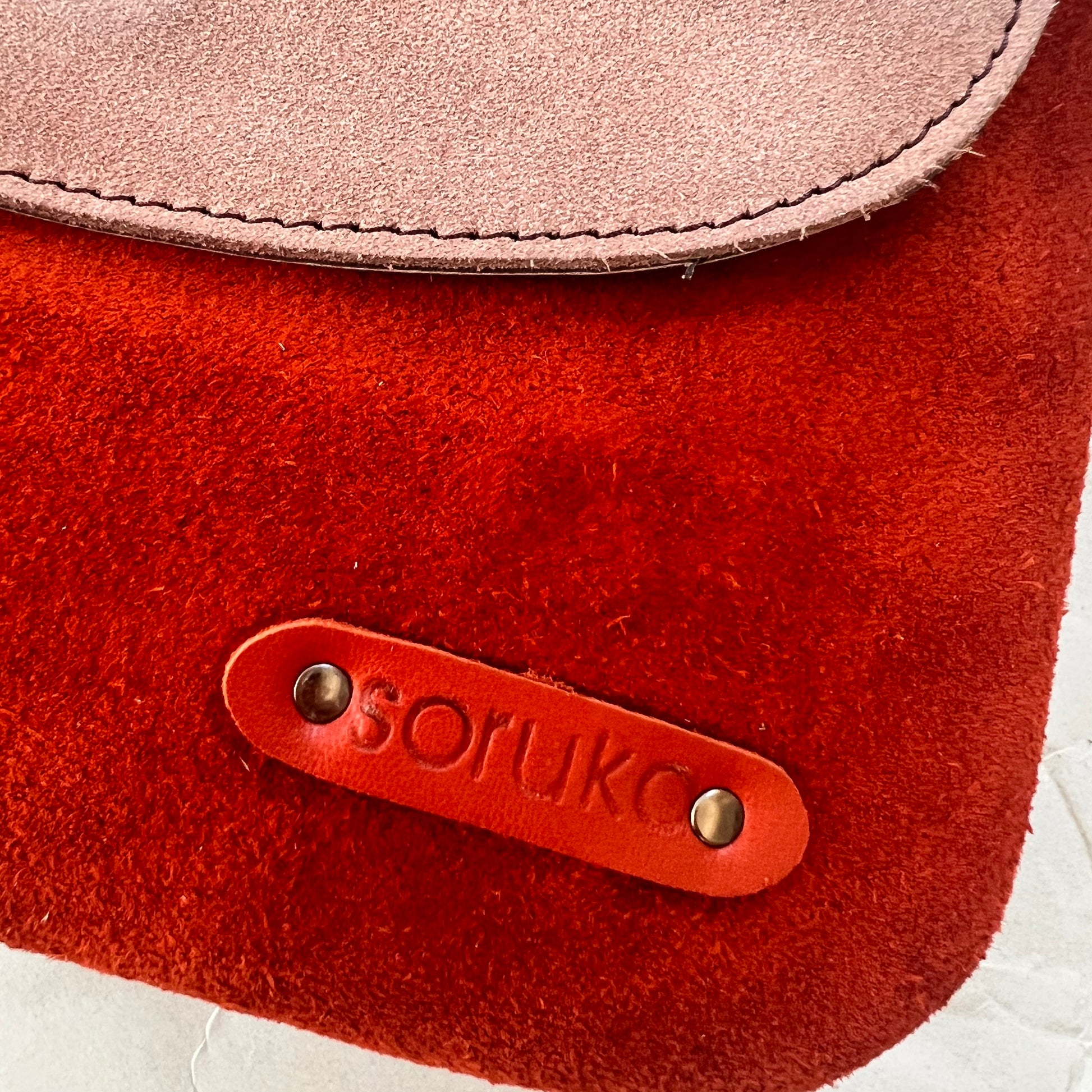 close-up of corner of purse showing "soruka" logo.