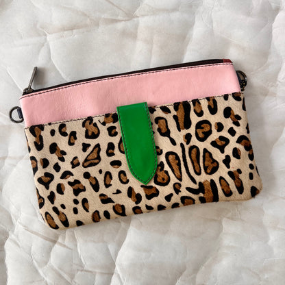 pink rectangular bag with cheetah print hair-on-hide pocket, and green tab.