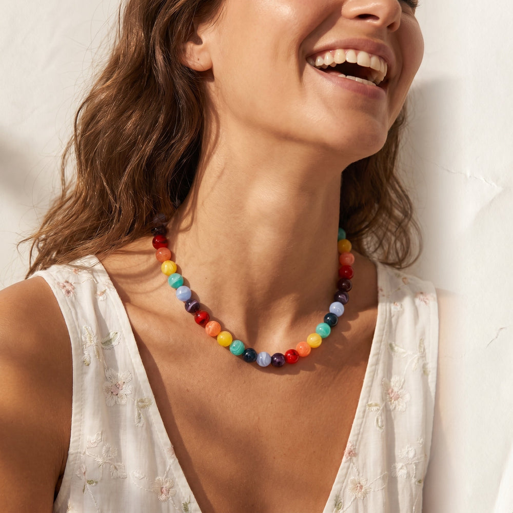 a person wearing the chunky rainbow beaded necklace