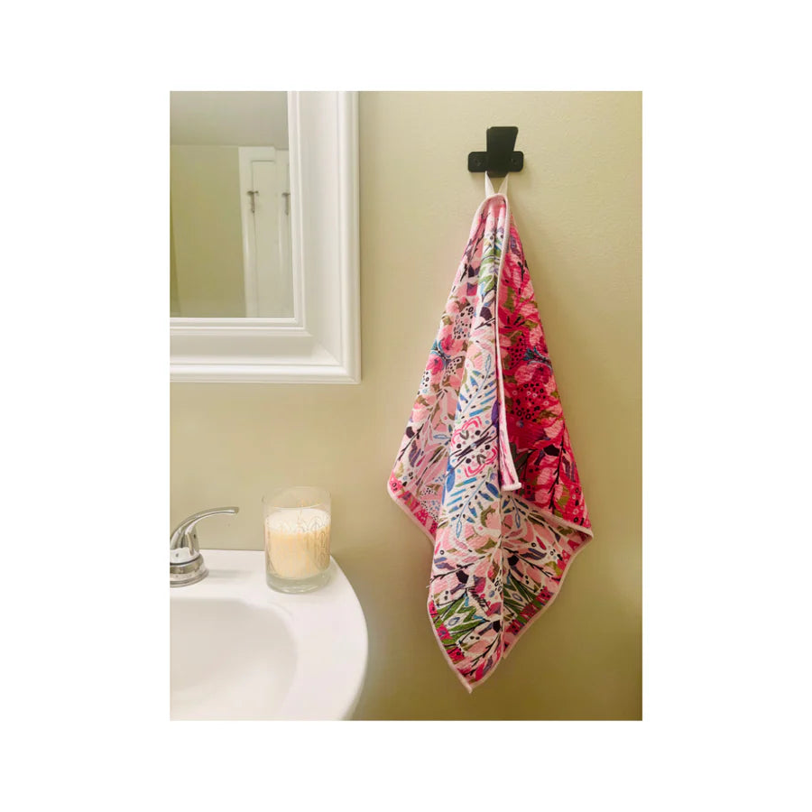 Floral-patterned towel hanging on a hook in a bathroom.