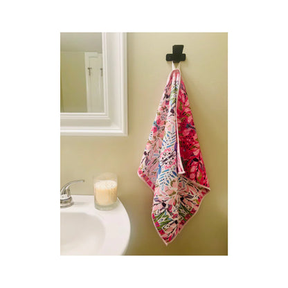 Floral-patterned towel hanging on a hook in a bathroom.