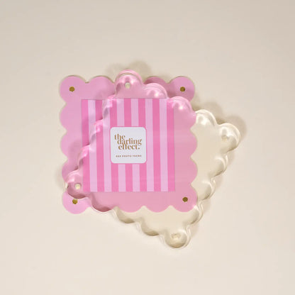 pink acrylic frame partially separated by the magnet to allow for replacing a photo