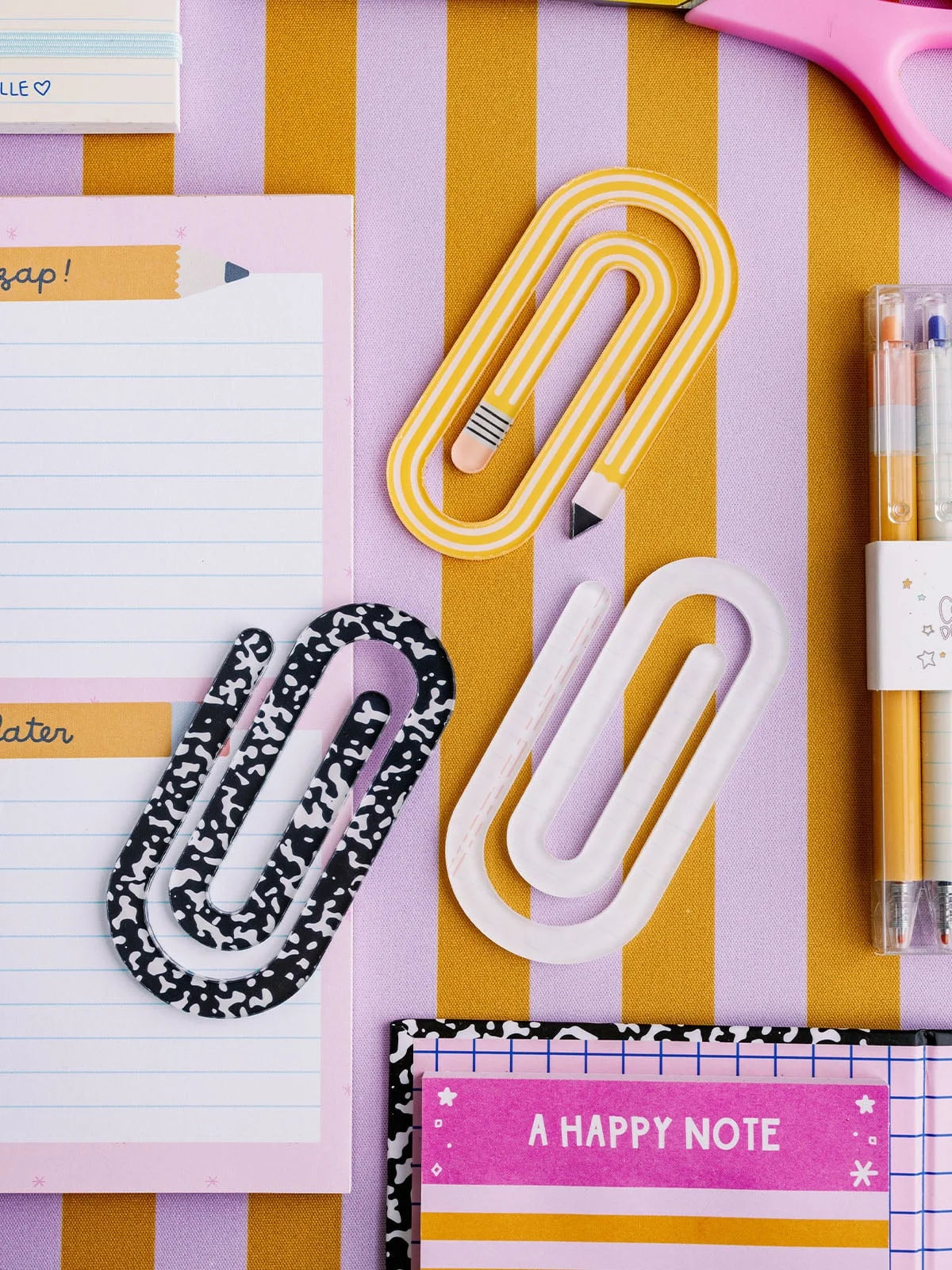 3 oversized paper clips on a decorated surface